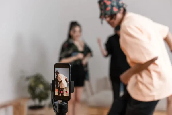 Vibrant indoor scene of people dancing recorded on a smartphone for a social media platform.