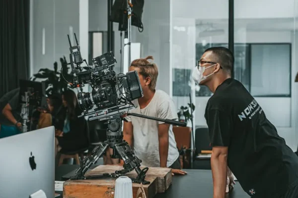 A professional film crew collaborates in a modern studio setting, focusing on high-end camera equipment.